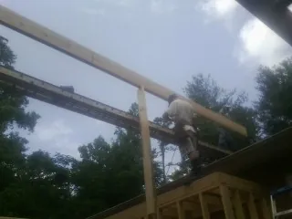 Carpenter setting a ridge beam over a new addition frame — Ice Dam Removal by Roofing Brothers in Talmage