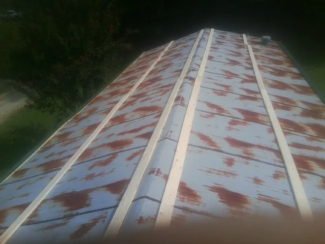 Rusted metal roof panels with new wood purlins before replacement — Storm Damage Roof Repair in Talmage by Roofing Brothers