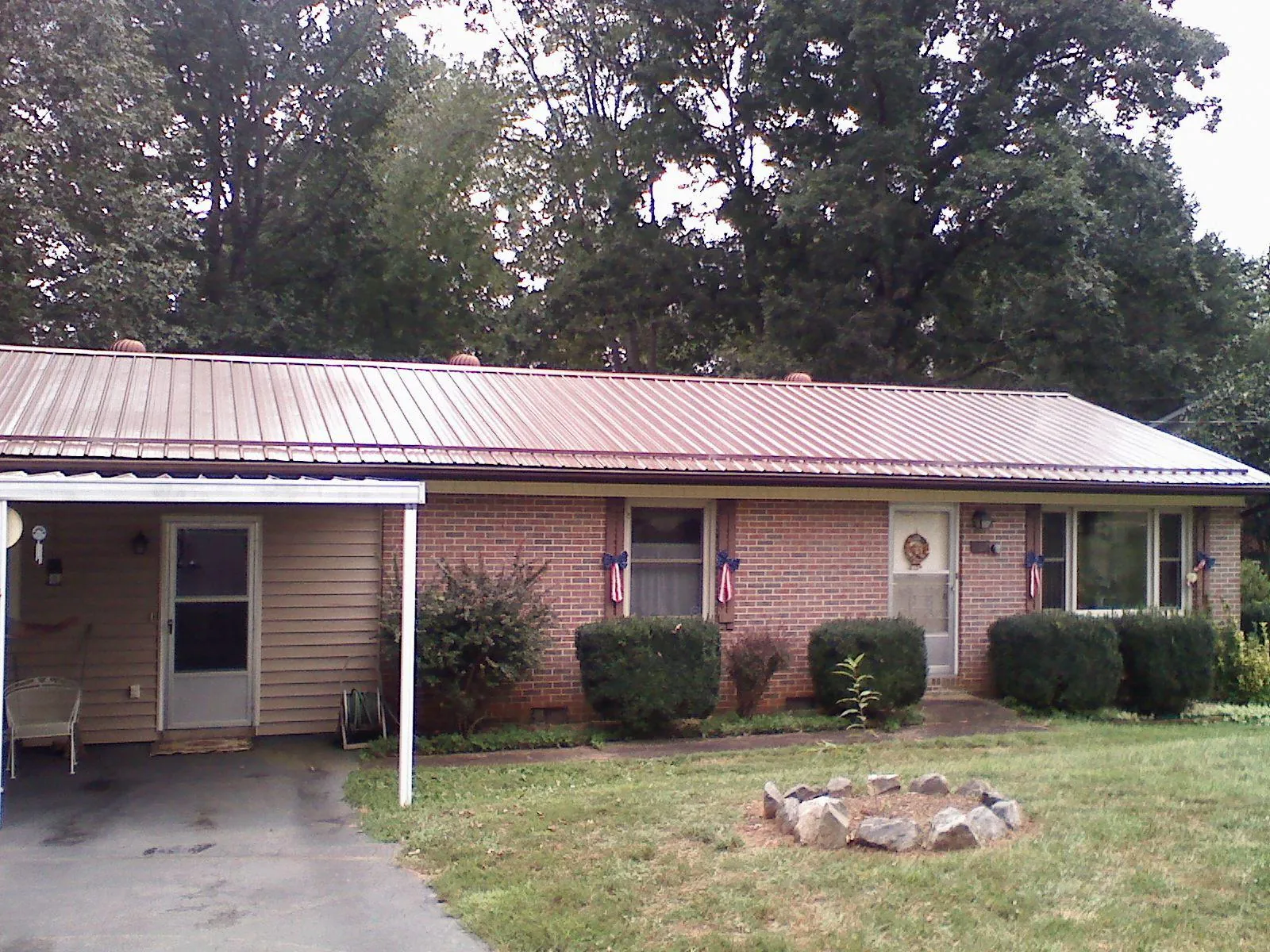 Bronze metal roof and carport on a brick ranch home — Roof Repair work by our crew in Talmage